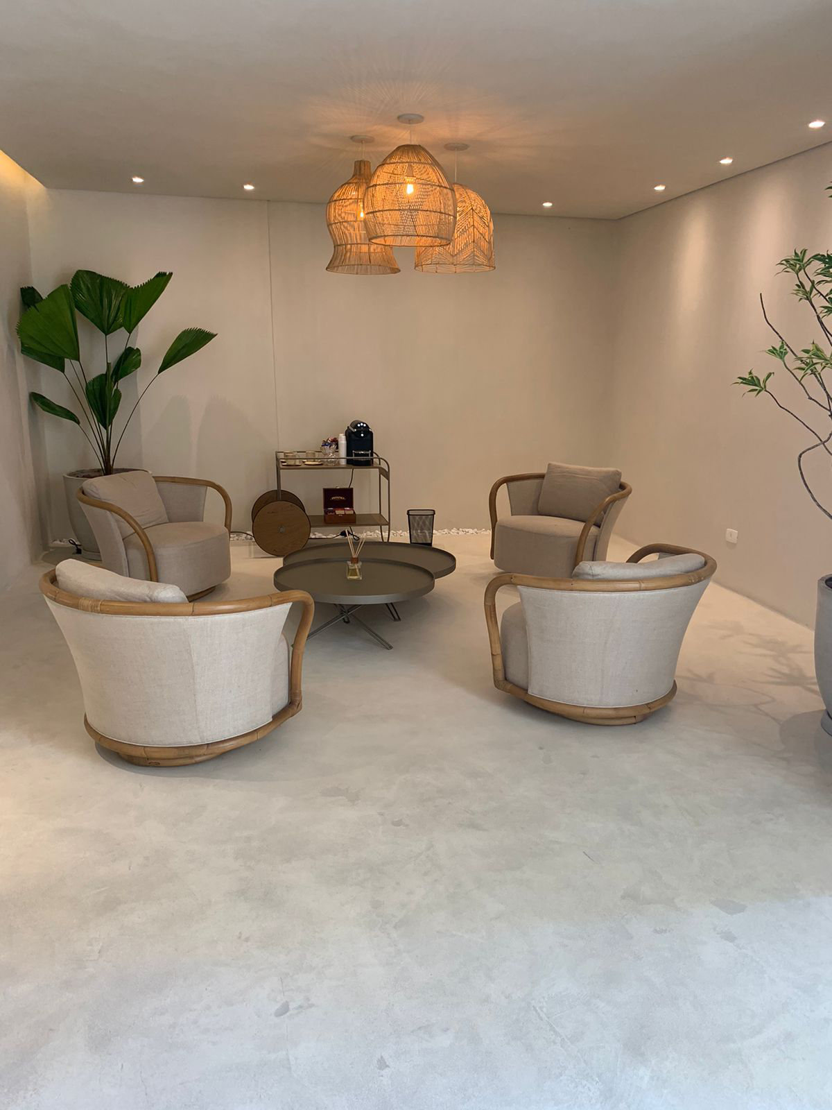 Sala de espera com poltronas e luminária de palha